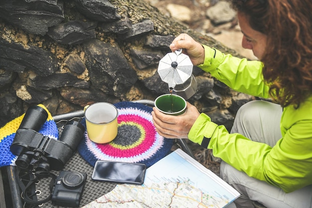 Photo une femme versant du café dans une tasse dans la forêt