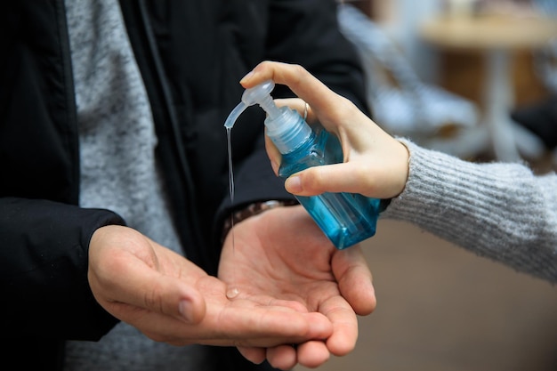 Femme versant du gel à la main de l'homme