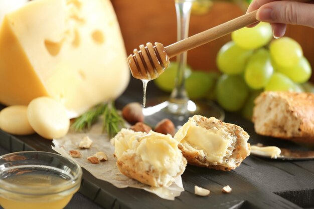 Femme versant du miel sur du pain avec du fromage