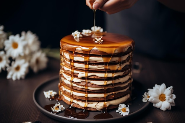 Une femme versant du miel sur un gâteau au miel avec de la crème au chocolat