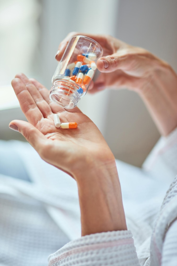 Photo femme versant des pilules de vitamines sur la paume