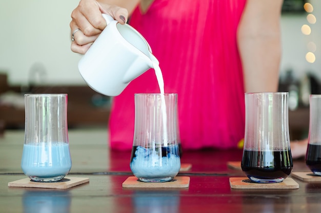 Photo une femme verse du thé dans quatre verres.