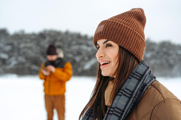 Femme en veste chaude d'hiver marchant dans la forêt d'hiver enneigée