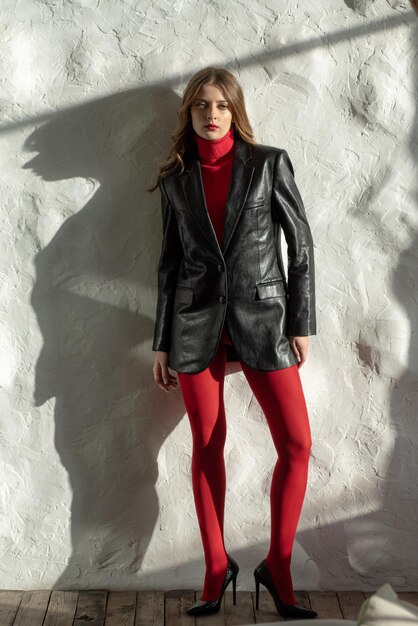 Femme avec une veste en cuir noire et un pantalon rouge