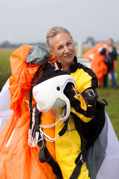 Une femme en veste jaune avec un casque blanc sur la tête.