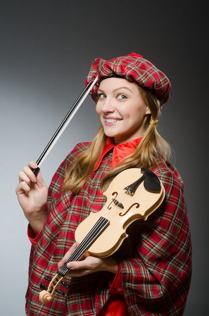 Femme en vêtements écossais dans le concept musical