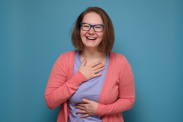 Femme en vêtements roses riant sur une blague amusante ayant une bonne humeur positive S