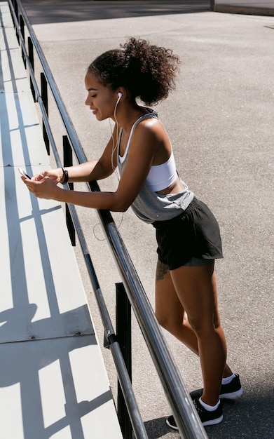 Femme en vêtements de sport debout à l'extérieur