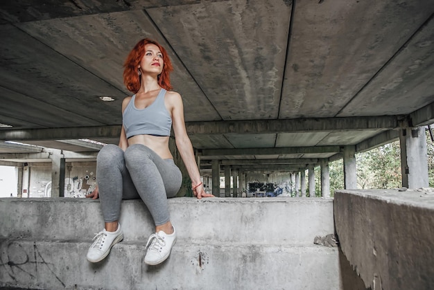 Photo femme en vêtements de sport et sa seule chaussure sous un exercice féminin sportif sur fond de pont