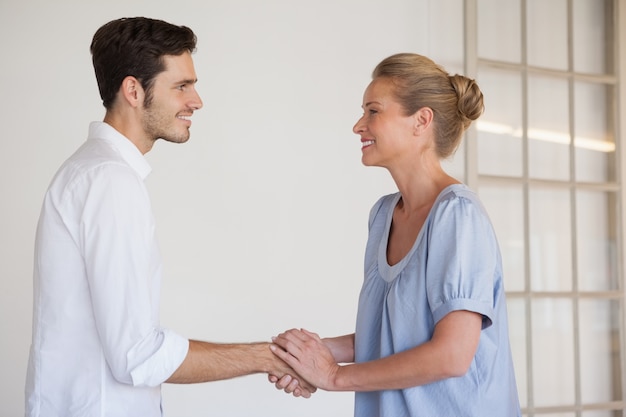 Femme de vêtements de travail se serrant la main avec l&#39;homme