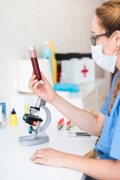 Femme vétérinaire tenant un tube à essai avec un échantillon de sang