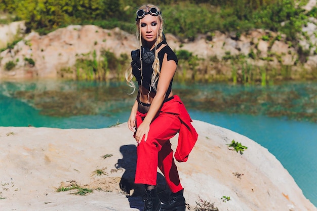 Femme vêtue d'un costume steampunk dans une attitude provocante avec son respirateur bras croisés sur le visage sur le fond d'un lac sale