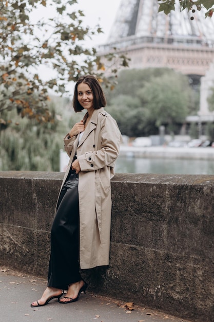 Femme vêtue d'un manteau marchant sur la célèbre place avec vue sur la Tour Eiffel