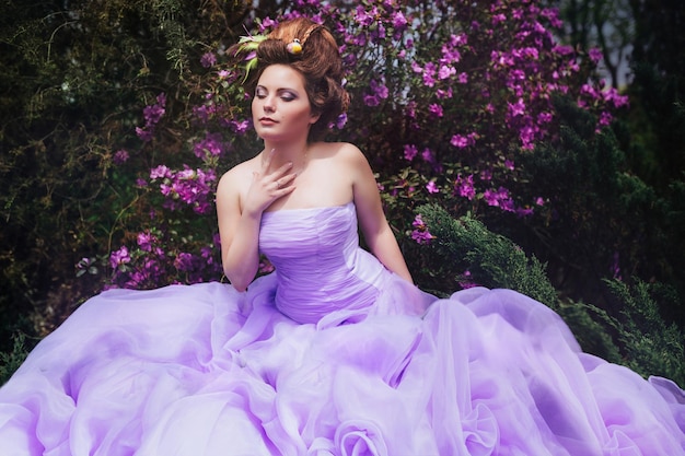 Photo femme vêtue d'une robe rose marchant dans un jardin fleuri