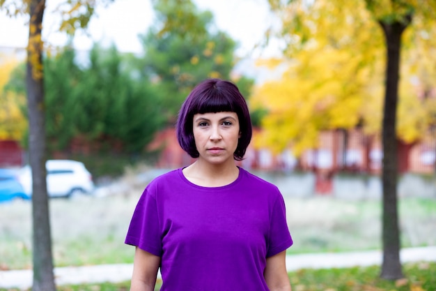 Femme en violet avec un arbre jaune de fond.