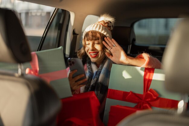 Femme en voiture avec des cadeaux de Noël