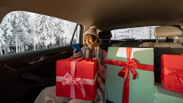 Femme en voiture avec des cadeaux de Noël