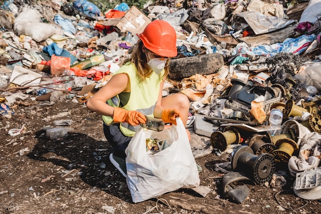 Une femme volontaire aide à nettoyer le champ des déchets plastiques.