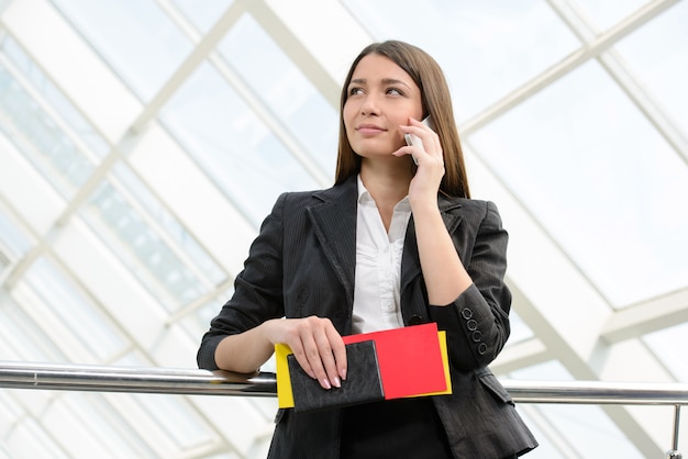 Femme en voyage d'affaires avec sac et tient le téléphone.