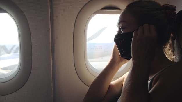 Une femme voyage caucasienne dans un avion avec un masque médical de protection Une touriste dans un avion avec un respirateur de protection Coronavirus covid19