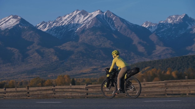 La femme voyage en cyclotourisme en terrain mixte avec bikepacking. Le voyage du voyageur avec des sacoches de vélo. Bikepacking de tourisme sportif.