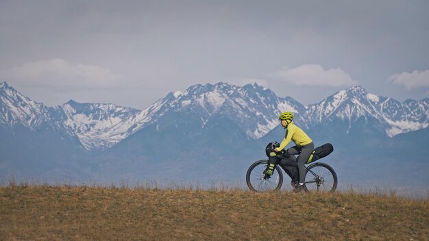 La femme voyage en cyclotourisme en terrain mixte avec bikepacking