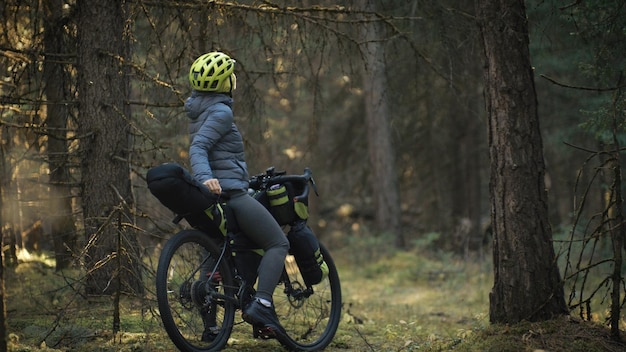 La femme voyage en cyclotourisme en terrain mixte avec bikepacking