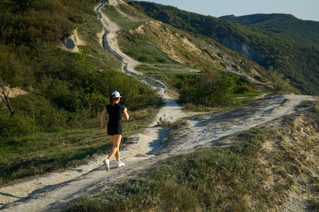 Photo femme sur un voyage de jogging dans les montagnes sur la côte de la mer