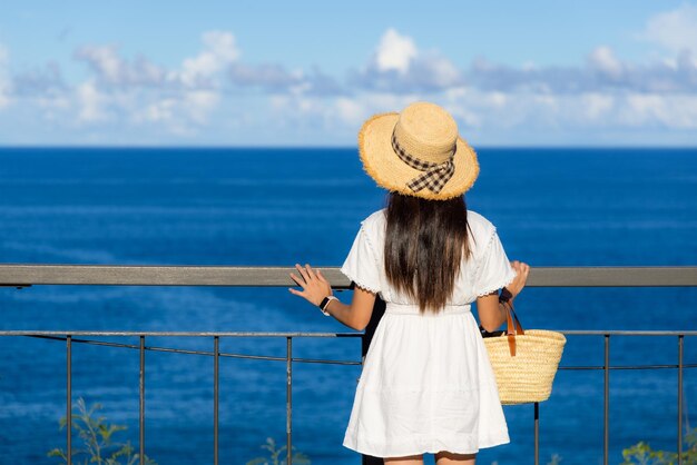 Femme de voyage regarde la mer