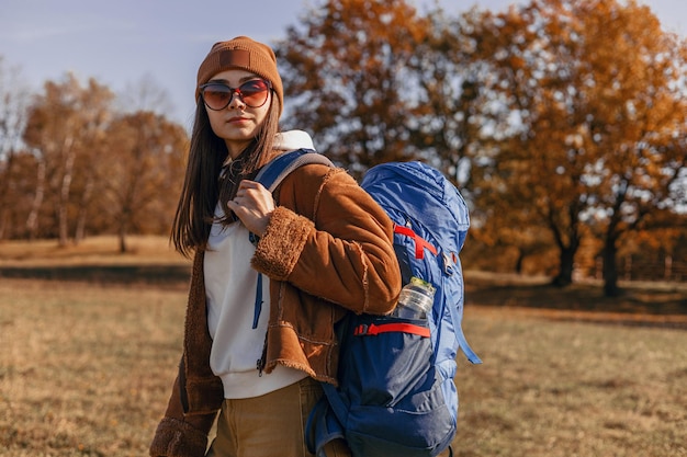 Femme voyageant avec sac à dos en marchant dans la nature pendant le trekking en automne