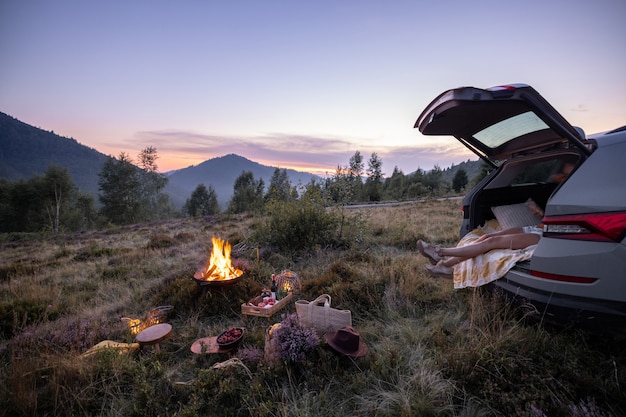 Femme voyageant en voiture et pique-niquant dans les montagnes