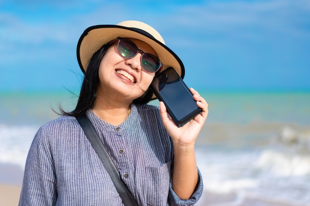 Femme de voyageur à l&#39;aide de smartphone sur la plage