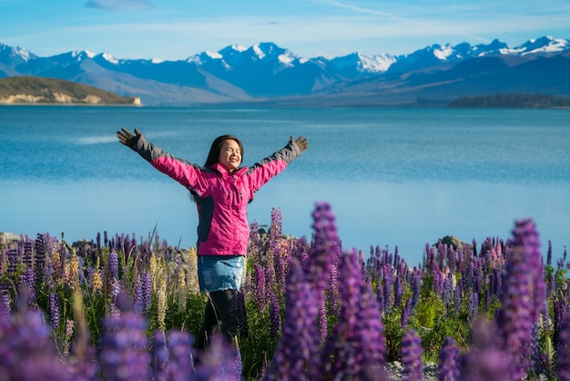 Femme voyageur au lac Tekapo, Nouvelle-Zélande. La fleur de lupin au lac Tekapo a atteint sa pleine floraison en décembre.