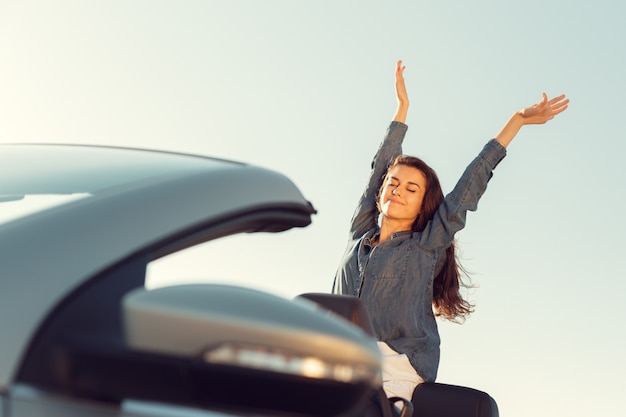 Femme de voyageur heureux en voiture cabrio