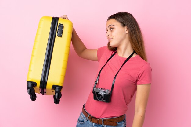 Femme voyageur sur mur rose isolé