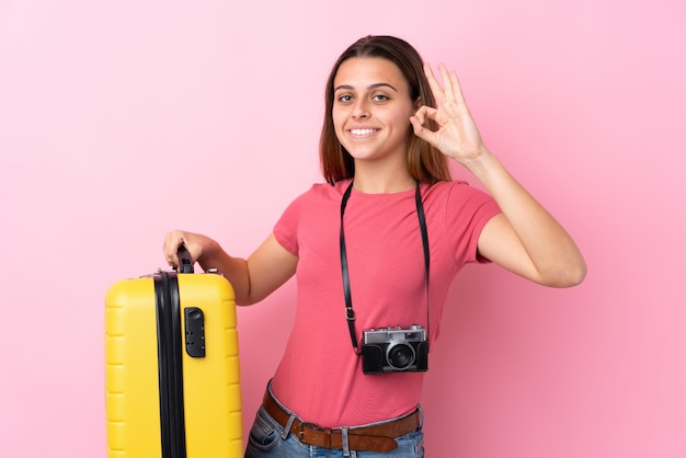 Femme voyageur sur mur rose isolé