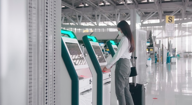 Une femme voyageur porte un masque de protection à l'aéroport international, voyage sous la pandémie de Covid-19.