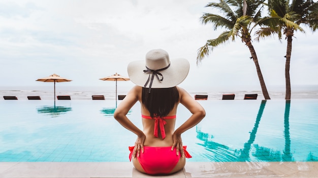 Femme voyageur relaxant dans la piscine