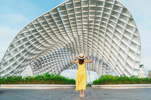 Femme voyageur avec une robe jaune visitant la ville de Da Nang Touriste visitant le bâtiment de la ville Point de repère et populaire pour l'attraction touristique Concept de voyage au Vietnam et en Asie du Sud-Est