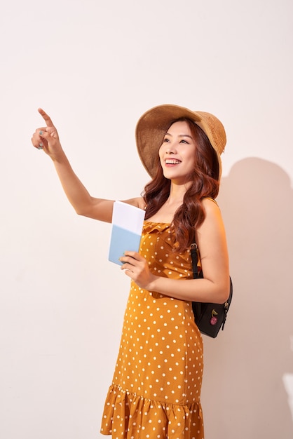 Femme voyageur tenant un passeport et un doigt pointé vers le haut