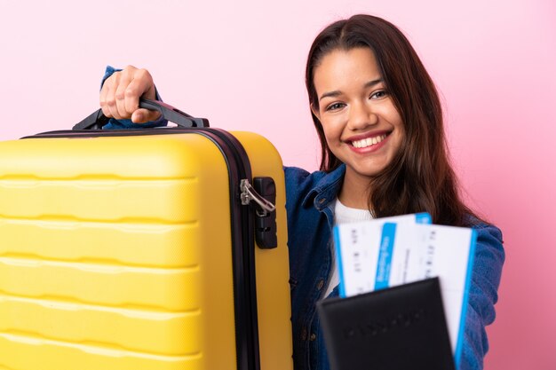 Femme voyageur avec valise sur mur isolé