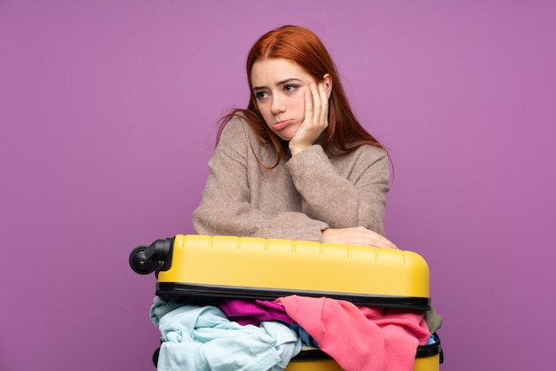 Femme de voyageur avec une valise pleine de vêtements