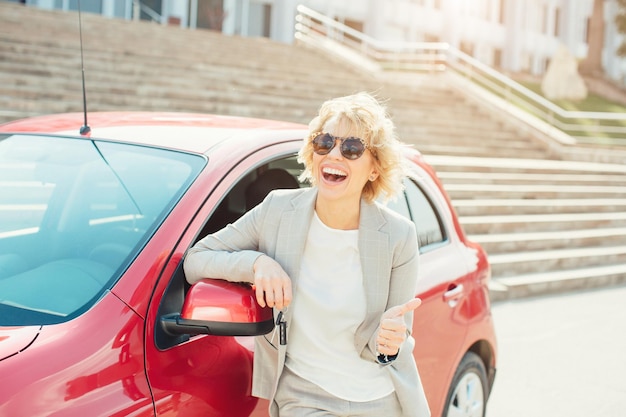 Femme voyageuse assise sur une voiture à hayon avec fond de montagne dans un ton vintage