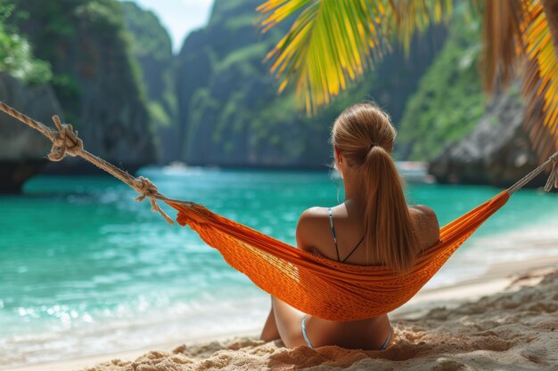 Une femme voyageuse se détend dans un hamac sur la plage d'été de Thaïlande sans montrer le visage à l'arrière vue sur un jour d'été ensoleillé