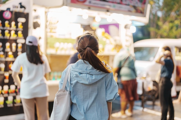 Femme voyageuse visitant le marché des camions de nourriture Touriste avec sac visites dans la rue du marché du week-end