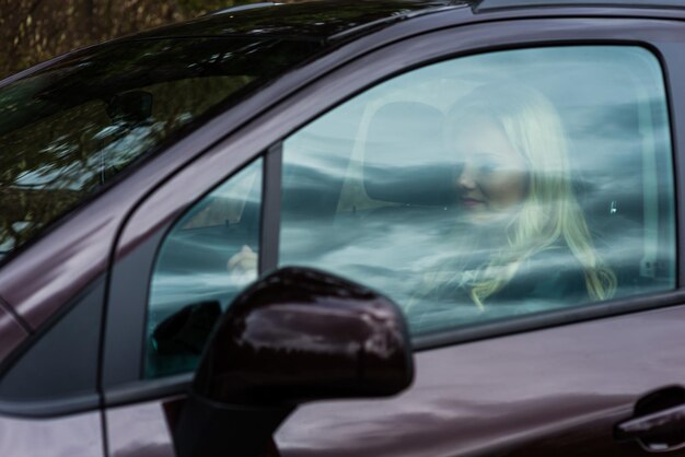 Photo femme vue par la fenêtre de la voiture