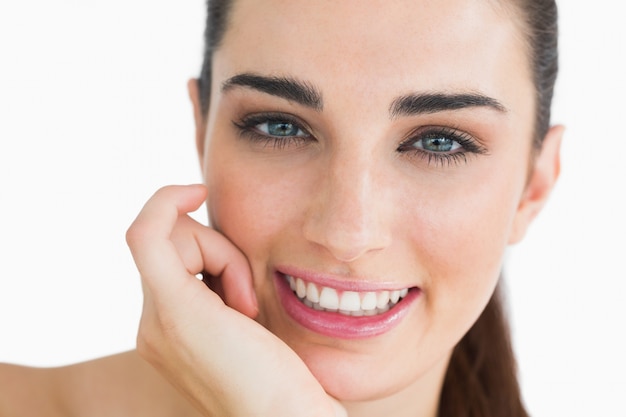 Femme avec des yeux clairs regardant la caméra et souriant