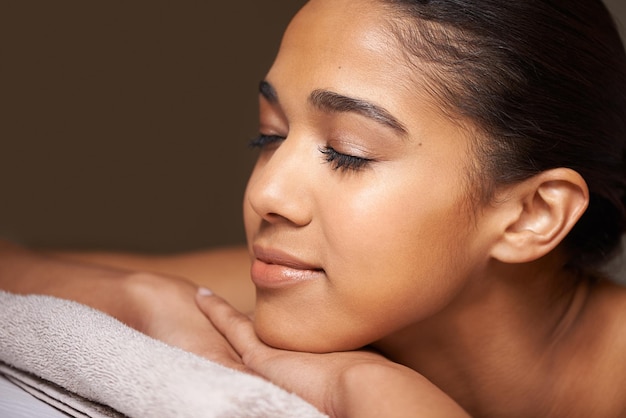 Femme yeux fermés ou massage à l'hôtel pour se détendre pour un repos zen ou une thérapie physique de bien-être dans un spa de luxe