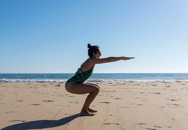 Femme de yoga faisant une pose de yoga sur la plage pour un mode de vie sain et bien-être.