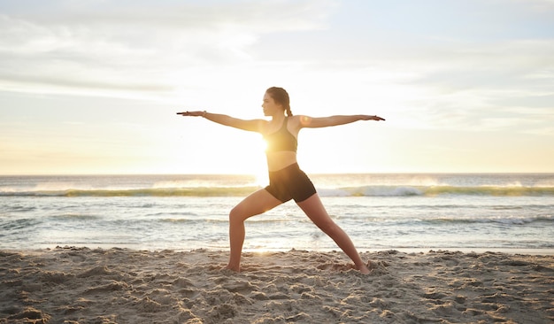 Femme yoga et méditation sur la plage pour un bien-être spirituel zen ou une séance d'entraînement au coucher du soleil à l'extérieur
